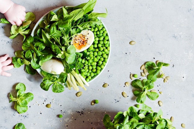 Soft-boiled eggs with lettuce, wild garlic, green peas and parsley.