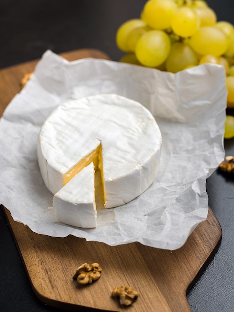 Soft cheese. Camembert and grapes on a wood with nuts