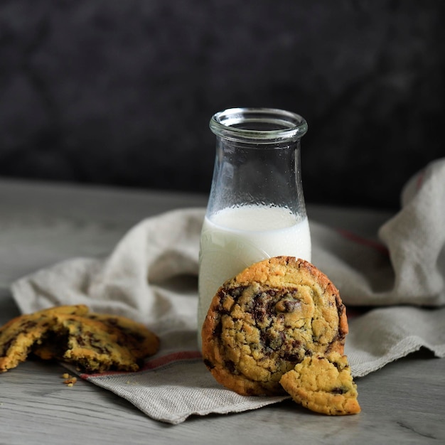 Soft and Chewy Chocolate Chip Cookies with a Bottle of Milk on a Wooden Table