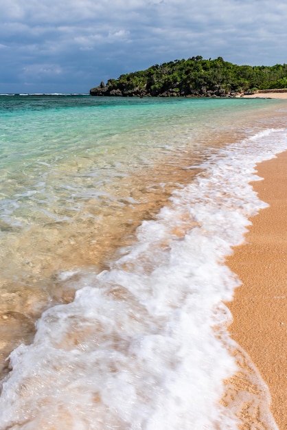 Soft crystal clear wave breaking along the seashore white foam Selective focus