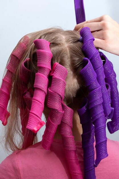 Foto soft curler spirals of long curlformers op de achterkant van het hoofd meisje modeaccessoire voor kroezen