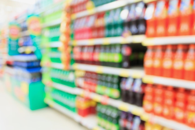 Soft drink bottles on shelves in supermarket blur background