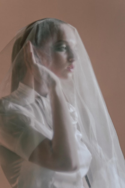 Soft fashionable portrait of a bride under a veil