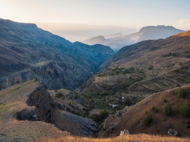 소프트 포커스입니다. 다게스탄(Dagestan)의 큰 록키 산맥과 장엄한 깊은 협곡의 실루엣이 있는 다채로운 일몰 풍경.