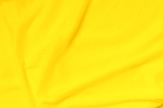 Soft focus gele gladde rimpel linnen stof textuur achtergrond geel is de kleurentrend van 2021
