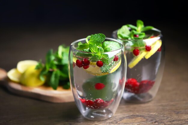 Soft focus Macro Detox drink with cranberries mint and lemon in a glass on a dark background Healthy beverage