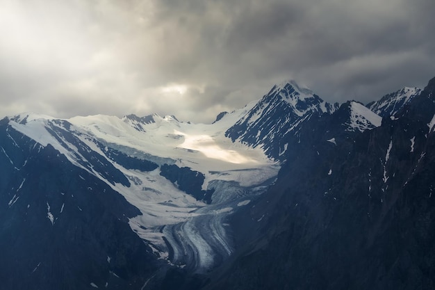 ソフトフォーカス暗い朝の山々の天国の神秘的な日光闇の山頂の劇的な空劇的な山々のある神秘的な氷河の背景