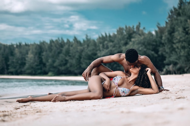 Soft focus portrait of a loving African American couple lying near the sea and kissing. Phuket. Thailand. Trip to warm destination