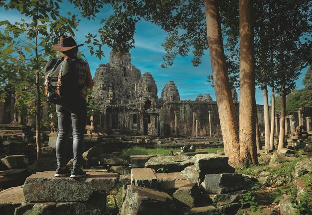 Photo soft focus on tourist standing in front of angkor wat temple in siem reap cambodia angkor wat is the largest religious monument in the world