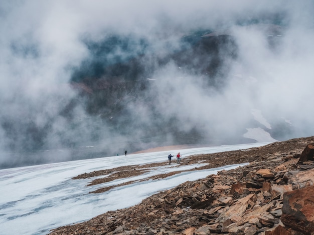 Soft focus. Tourists come to top of misty snowy hill. teamwork and victory, teamwork of people in difficult conditions. Difficult climb to the top of the mountain.