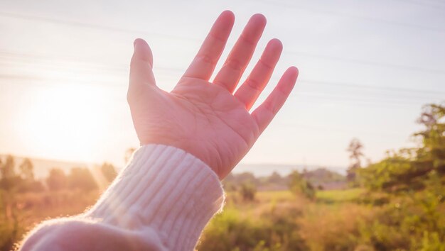 soft focus Woman hand reaching towards nature and sky