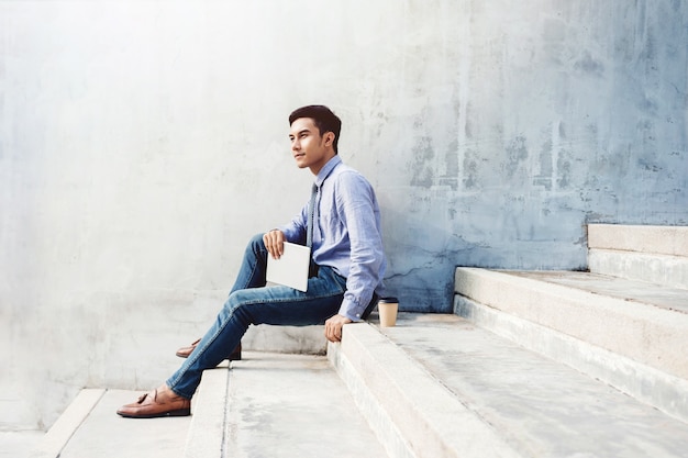 Soft focus of Young Businessman working on tablet at outdoor stair