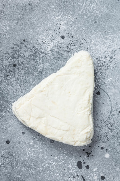 Soft goat and sheep milk cheese. Gray background. Top view.