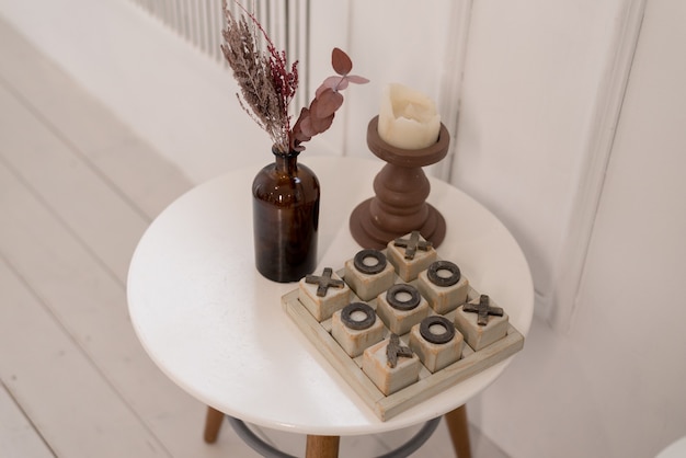 Soft home decor made of glass vase with spikelets and wood play on white table. Interior.