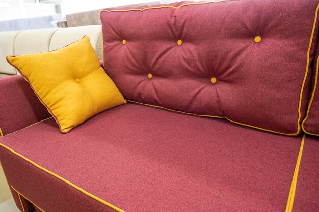 A soft new burgundy sofa with a decorative pillow