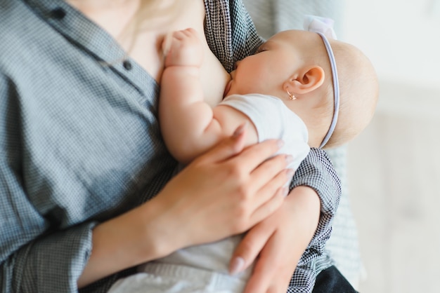 写真 柔らかい写真若い母親が白い部屋で自宅で赤ちゃんを授乳