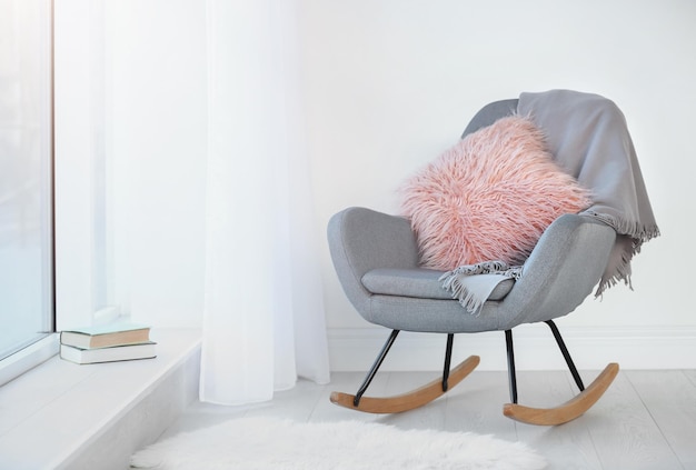 Photo soft pillow and plaid on armchair in room