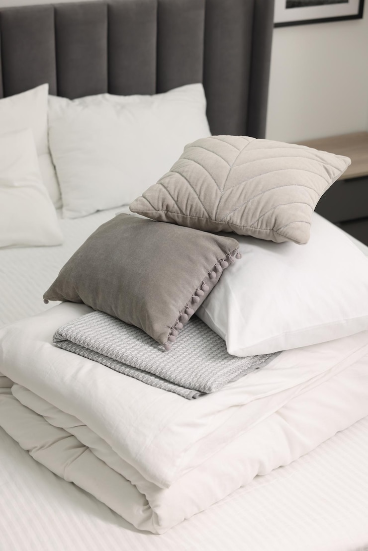 Photo soft pillows and bedding set on bed at home