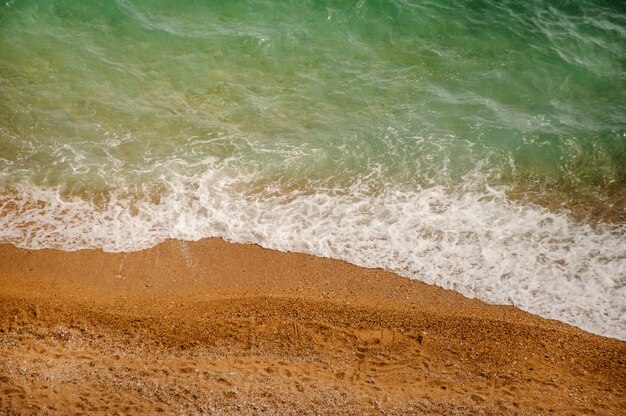 Soft sea wave on a sandy beach and pebble beach