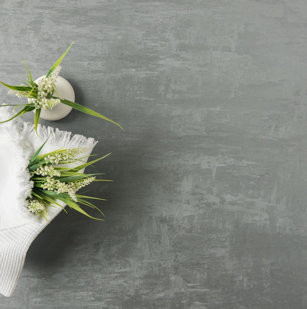 Soft towel with a flower in a grey  decorative stucco background. top view, isolated