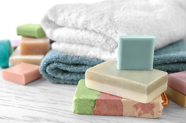 Soft towels and different soap bars on table