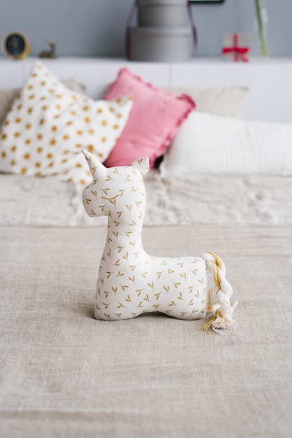 Soft unicorn toy on the bed in the bedroom 