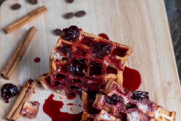 Soft waffles with red cherry jam on a serving board