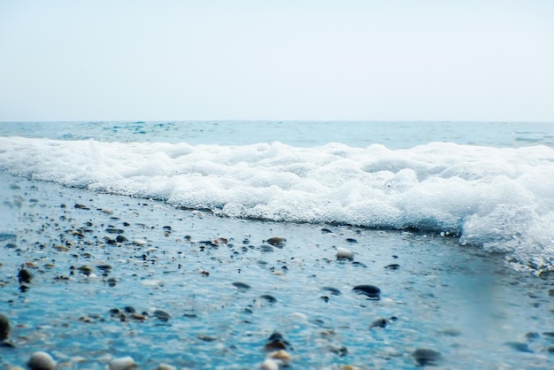 砂浜の背景に青い海の柔らかい波