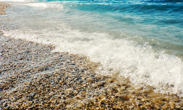 砂浜の背景に青い海の柔らかい波