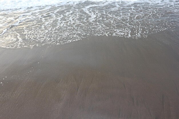 Soft wave of blue ocean on sandy beach. Background.