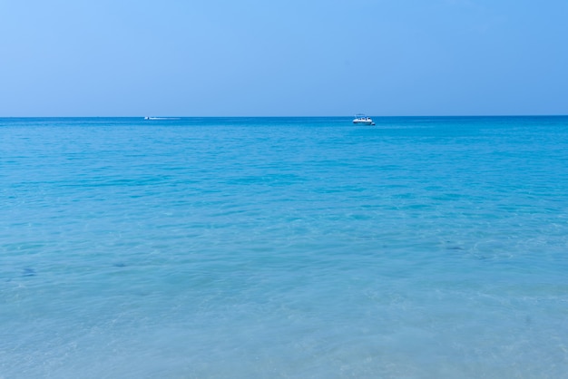 Foto morbida onda di oceano blu sulla spiaggia di sabbia.