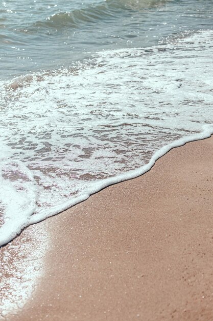 Soft wave of blue ocean on a sandy beach.