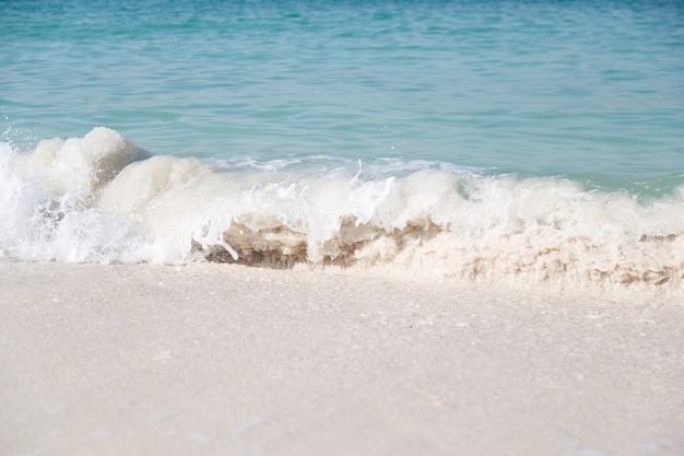 Soft wave of blue ocean on sandy beach.