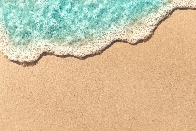 Мягкая волна складывается на пустой песчаный пляж, летний фон. Копировать пространство.