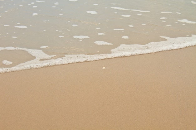 Foto morbida onda sulla spiaggia sabbiosa