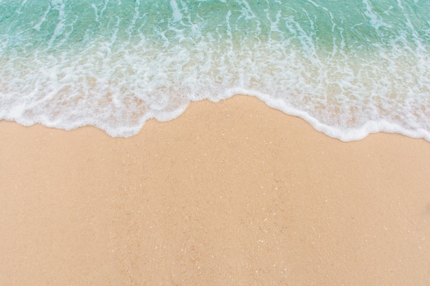Morbida onda di mare sulla spiaggia di sabbia vuota sfondo con lo spazio della copia