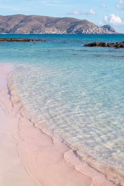 Soft waves of the sea on the pink sand and beautiful beach with cliffs