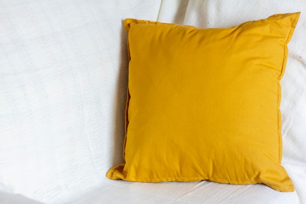 Photo a soft yellow or mustard-colored pillow on a cozy sofa.
