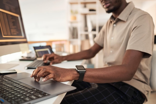 Software developer wearing smartwatch when working on computer in office