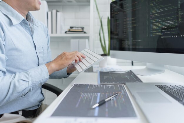 Photo software development concept male programmer using keyboard to typing data codes on computer