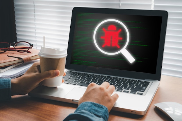 Software development and debugging concept Person hand using laptop computer with bug software icon on screen Software security Computer bug failure or error of software