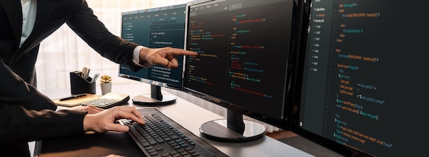 Команда разработчиков программного обеспечения работает вместе в офисе, отображая сценарий кодирования на мониторе компьютера. Программист и инженер-программист, работающий в компании-разработчике технологий Trailblazing