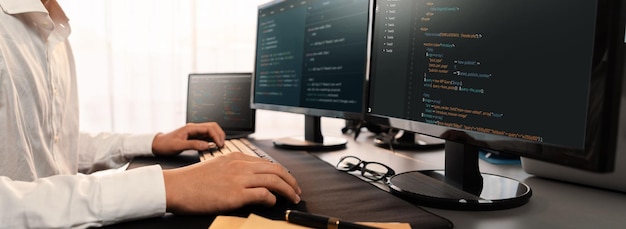 software engineer working on application development on his computer display code and script on monitor at tech company office workplace application developer solving and writing code trailblazing