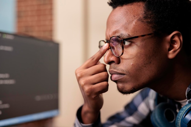 Softwareontwikkelaar die machine learning servercode op de computer typt, zit aan een bureau in een softwarebedrijf. Programmeerder die aan een databasesysteem werkt met een coderingsscript in het agentschap