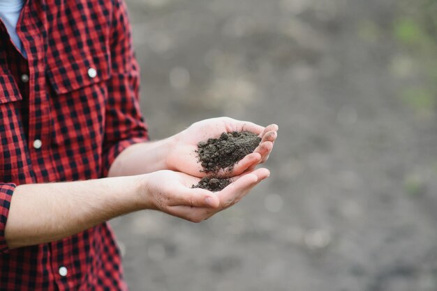 Soil in farmer arms image with selective focus