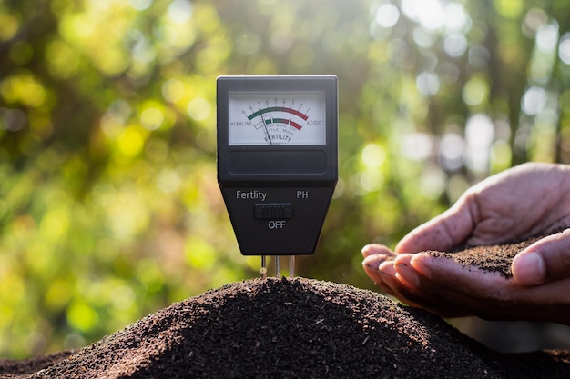 Photo soil meter on earthworm manure for cultivation and there was a man's hand holding soil in his hand