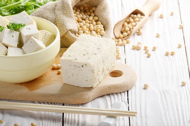 Soja Bean curd tofu in kleikom en in hennepzak op witte houten keukentafel Nondairy alternatief alternatief voor kaas Plaats voor tekst