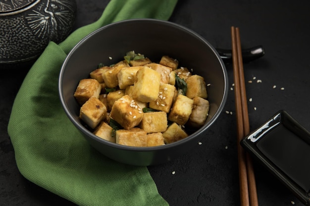 sojaproduct gebakken tofu banner op een zwarte achtergrond en groen servet Alternatief eiwit Veganistisch