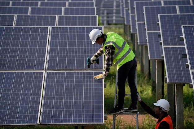 太陽電池技術エンジニアは、工場の屋根の再生可能エネルギーの概念における太陽電池の設置と太陽電池の修理を調査しています