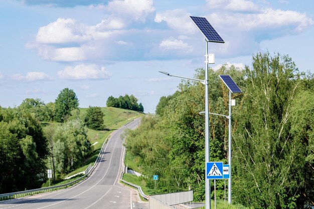青い空を背景に街路灯を備えたソーラー デバイス バッテリーを含むソーラー パネルを搭載した街路灯 太陽からの代替エネルギー